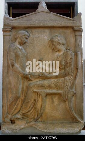 Grave Stele of Hegeso. Relief depicting Hegeso picking a jewel from the open pyxis (jewelry box), seated before her young servant, ca. 410-400 BC. Pentelic marble. From the Kerameikos cemetery, Athens. National Archaeological Museum. Athens, Greece. Stock Photo