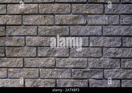 Old black brick seamless pattern wall texture background. Gray stone block rough and grunge surface pattern. Dark aged gloomy block masonry. Minimalis Stock Photo