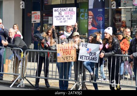 Spectators are seen holding Thank You signs for veterans during the veteran's day parade in New York City on November 11, 2019. Stock Photo