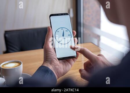 Man testing speed network with mobile phone. Concept of network speed and generations Stock Photo