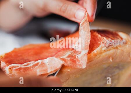 Jamon serrano. Traditional Spanish ham, Slicing of dry-cured ham in Spain Stock Photo