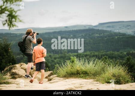 Father and son taking pictures in the mountains and admiring the landscape Stock Photo