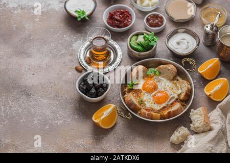 Traditional turkish breakfast with fried eggs, tea, vegetables, chees and olives, copy space Stock Photo