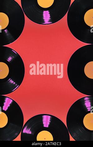old black vinyl records with blank orange labels on red background as frame Stock Photo