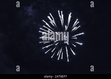 Cheap bluish fireworks against the dark sky. Stock Photo