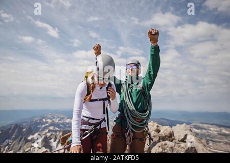 Smiling couple celebrates reaching the summit of the Grand Teton Stock Photo