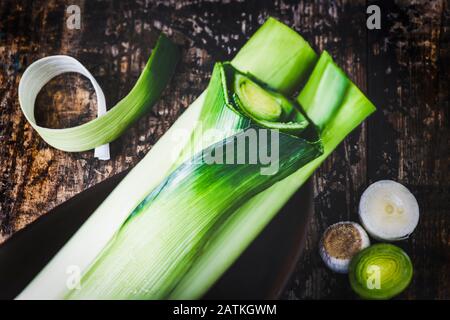 Leeks placed on  old wooden table dark filter, room for text over lay Stock Photo