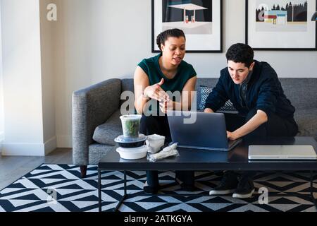 Confident business coworkers discussing over laptop at table in office Stock Photo