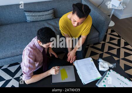 High angle view of male and female colleagues discussing over graphics tablet at table in office Stock Photo