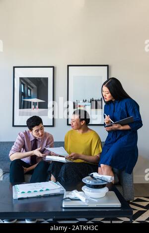 business colleagues discussing over documents in office Stock Photo