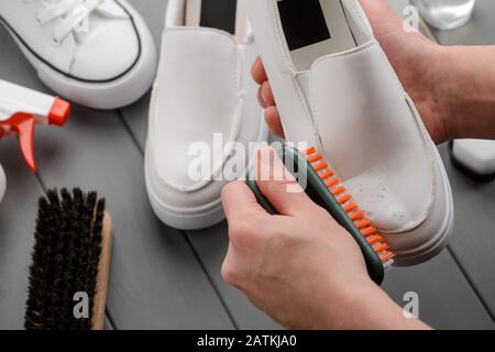 Washing Shoe with Foam Cleaner. White Leather Footwear and