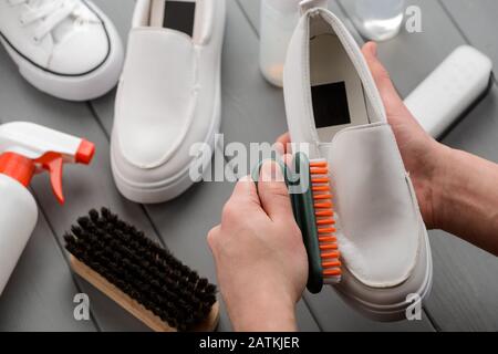 Washing Shoe with Foam Cleaner. White Leather Footwear and