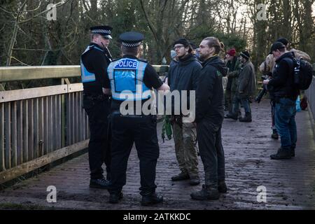 Denham, UK. 3 February, 2020. Police liaison officers monitor environmental activists from Extinction Rebellion, Save Colne Valley and Stop HS2 occupying a bridge in Denham Country Park to seek to prevent works for the HS2 high-speed rail link including the felling of 200 trees and the construction of a Bailey bridge, compounds, fencing and a parking area. Part of the location for the work lies within a wetland nature reserve forming part of a Site of Metropolitan Importance for Nature Conservation (SMI). In spite of a substantial police presence, HS2 were not able to proceed with the work for Stock Photo