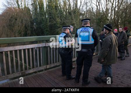 Denham, UK. 3 February, 2020. Police liaison officers monitor environmental activists from Extinction Rebellion, Save Colne Valley and Stop HS2 occupying a bridge in Denham Country Park to seek to prevent works for the HS2 high-speed rail link including the felling of 200 trees and the construction of a Bailey bridge, compounds, fencing and a parking area. Part of the location for the work lies within a wetland nature reserve forming part of a Site of Metropolitan Importance for Nature Conservation (SMI). In spite of a substantial police presence, HS2 were not able to proceed with the work for Stock Photo