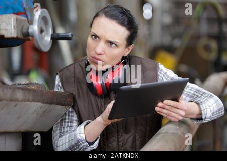 female technician taking notes with help of digital tablet Stock Photo