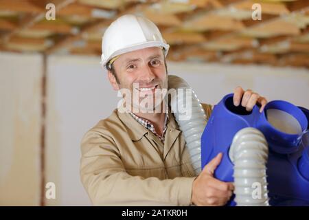 builder installer of ventilation with tools in hands Stock Photo