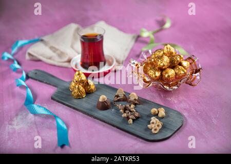 Chocolate candy in shiny wrapper. Delicious chocolate candies on wooden background. Ramadan Eid (Ramadan feast) Concept. Stock Photo