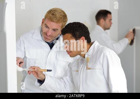 portrait of supervisor guiding trainee decorator Stock Photo