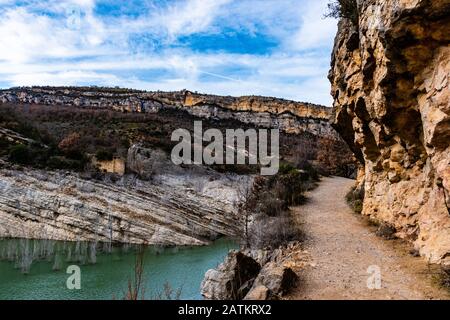 A pathway next to the rocky mountains and river of Congost de Mont-rebei in Spain Stock Photo