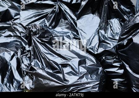 Black garbage bags lie on the ground. close up. Stock Photo