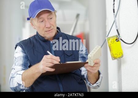 mature electrician with multimeter probe Stock Photo