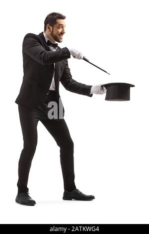 Full length shot of a wizard making a magic trick with a wand and a tophat isolated on white background Stock Photo