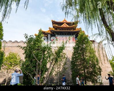 Tourists walking past Corner Tower and high wall, Forbidden City, Beijing, China, Asia