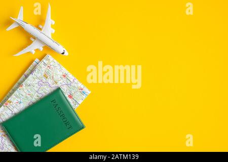 Summer travel concept. Flat lay traveler accessories on yellow background with copy space. Top view plane, passport, map. Travel agency banner design Stock Photo