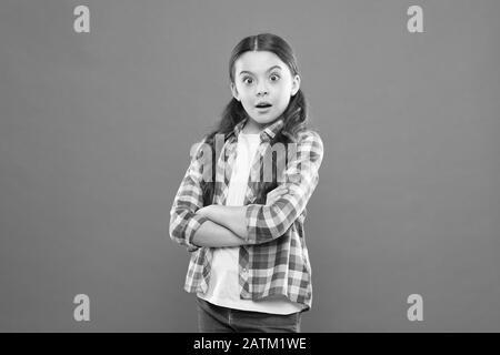 Wondering every day. Upbringing versatile personality. Childhood concept. Girl child stand orange background. Mentally and physically healthy child. Child care and psychology. Wellbeing and health. Stock Photo