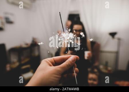 Details with the hand of a man holding sparklers hand fireworks. Stock Photo