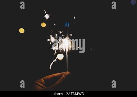 Details with the hand of a man holding sparklers hand fireworks. Stock Photo