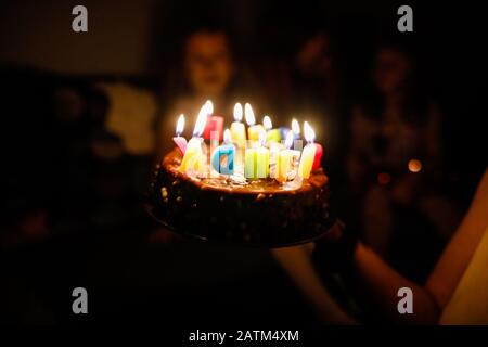 Shallow depth of field (selective focus) image with details of a birthday cake for a child with the Happy Birthday message made from candles. Stock Photo