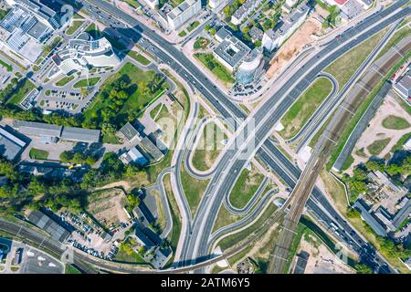 aerial top down view of asphalt road intersection and rail tracks in urban area Stock Photo