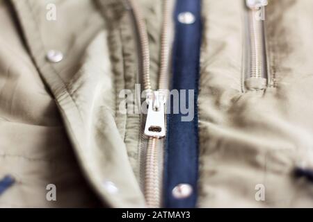 A half-open metal lock on a light khaki jacket. Stock Photo