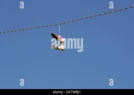 bowling shoes hanging on an electrical wire Stock Photo