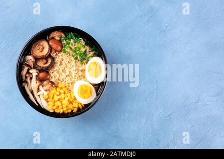 Ramen noodle soup. Soba with eggs, shiitake and enoki mushrooms, sweetcorn and scallions, shot from above with copy space Stock Photo