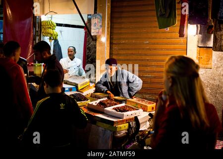 An elderly man at a medina market stall selling dates in Marrakesh, Morocco Stock Photo
