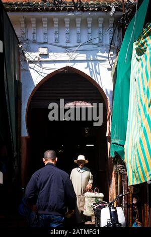People walk through a market area in the medina of Marrakesh, Morocco Stock Photo