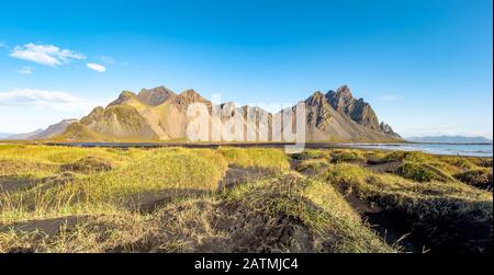 Epic view landscape of the black sand beach in Stokksnes on a sunny day. Vestrahorn mountain in the background. Nature and ecology concept background. Stock Photo