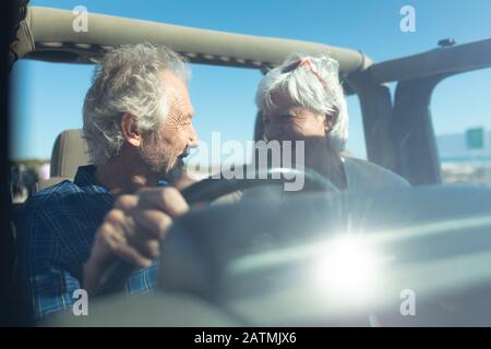 Old couple with a car at the beach Stock Photo