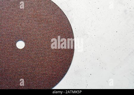 Segment semicircle of abrasive disc on a background of gray concrete close-up, image with copy space. Stock Photo