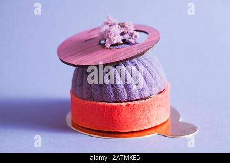 French pastry decorated with purple mirror glaze. Modern european cake with blueberry mousse. Stock Photo