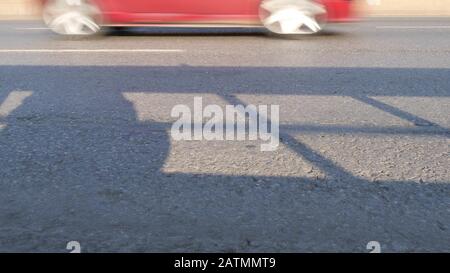 Cars passing at high speed in front of camera at asphalt road. Stock Photo