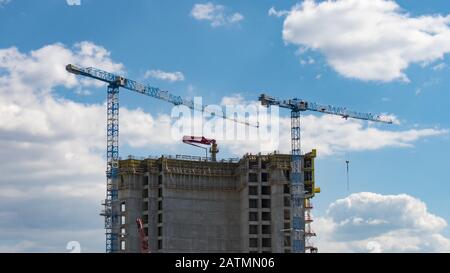View of skyscraper building construction with cranes on the roof. Stock Photo