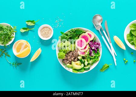 Vegan lunch bowl with quinoa, cucumber, green peas, radish, romanesco and red cabbage, avocado, spinach and arugula salad, healthy eating, vegetarian Stock Photo
