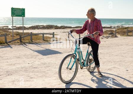 Old man with a bike at the beach Stock Photo