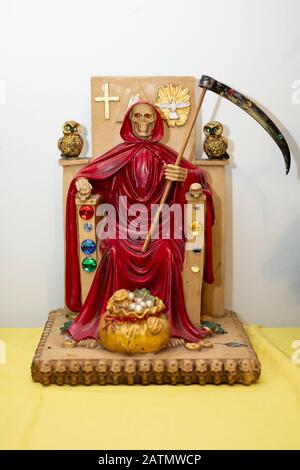 A red Santa Muerte statue displayed in a home temple in Jackson Heights, Queens, New York City. Stock Photo