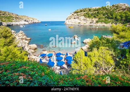 Small beach with tourists, umbrellas and sun chairs in Anthony Quinn bay (Rhodes, Greece) Stock Photo