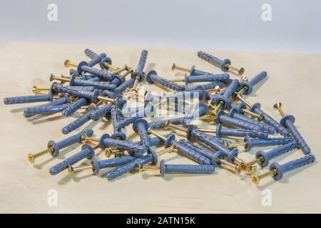 Dowel nails on wood background. Set of wall plugs. Stock Photo