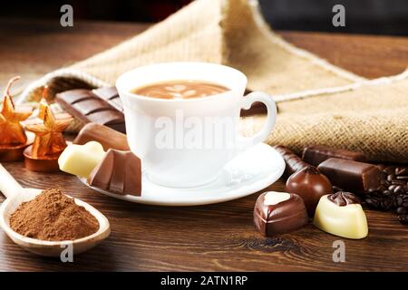 cup of delicious latte with chocolate and roasted coffee beans covered in burlap Stock Photo
